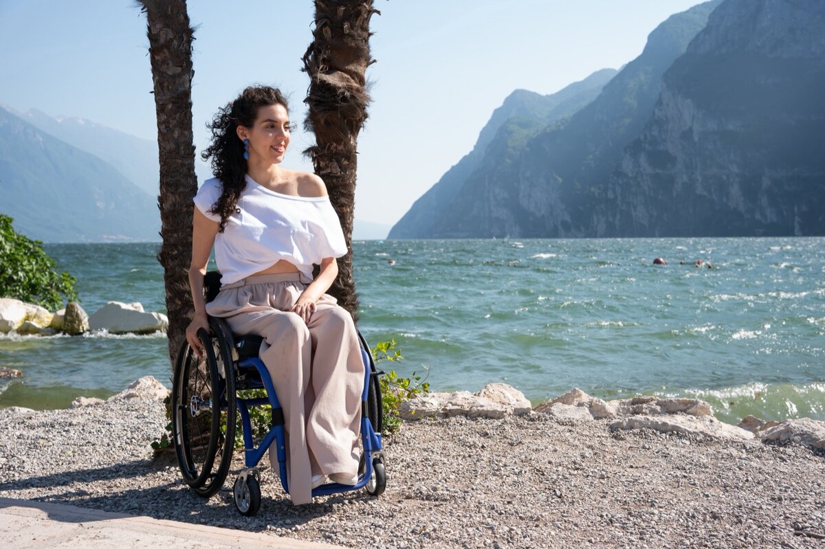 Una ragazza in carrozzina OFFCARR sulla riva del lago di Garda